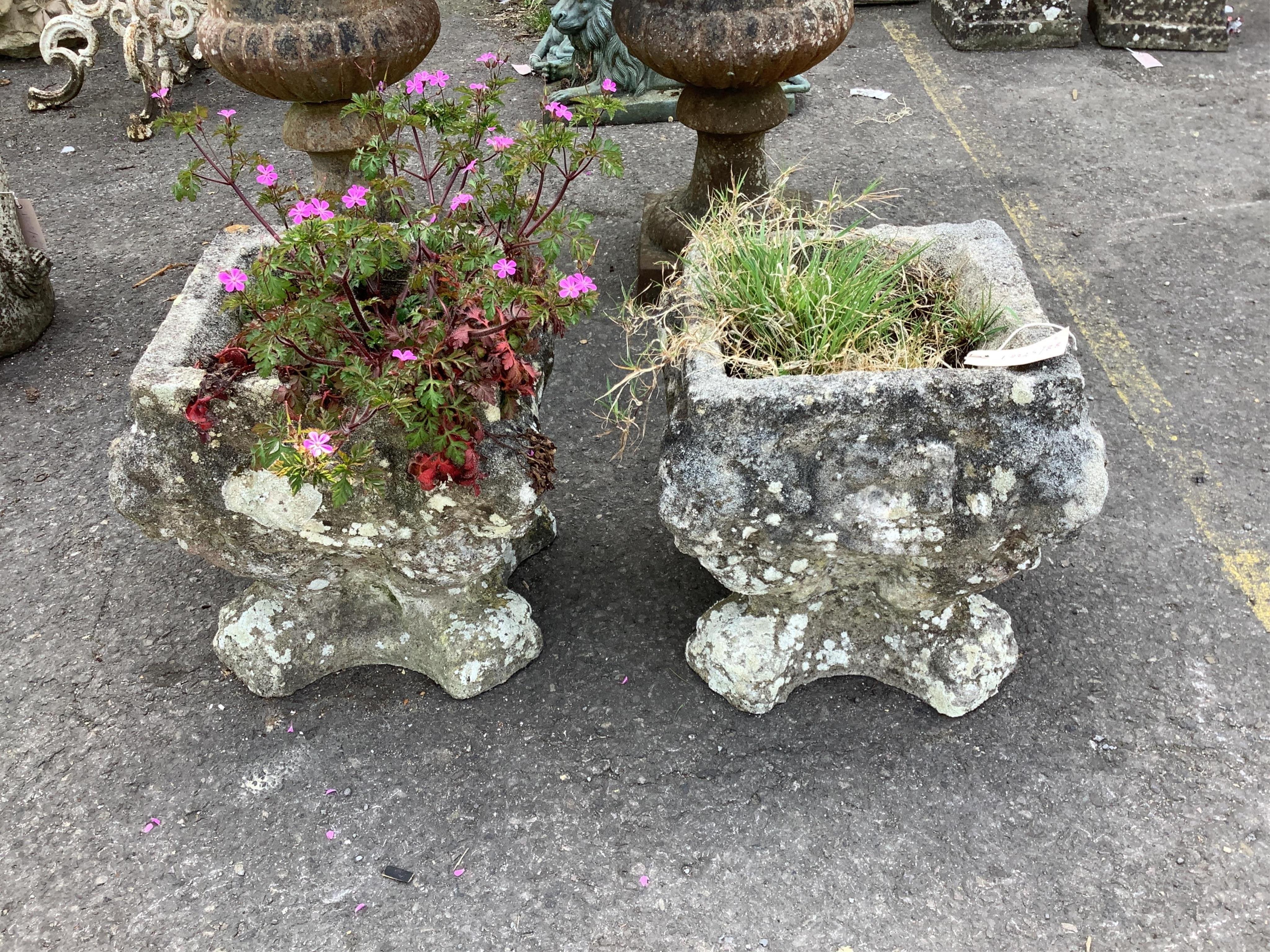 A pair of small reconstituted stone garden urns, moulded with lion masks, width 30cm, height 33cm